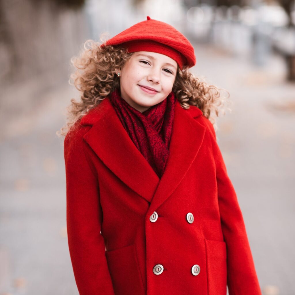 stylish kid girl 5 6 year old wear red hat and jacket over city